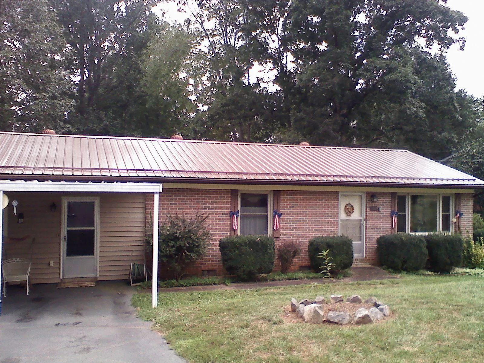 Bronze metal roof and carport on a brick ranch home — Roof Repair work by our crew in Cordesville